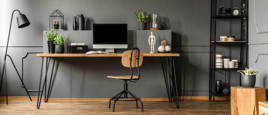 A perfect home office featuring a desk, chair, and greenery.