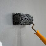 Colour Psychology into Interior Design - person painting a wall with a brush